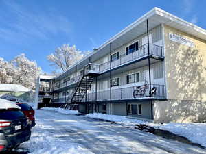 Snow covered building with a view of apartment building / complex