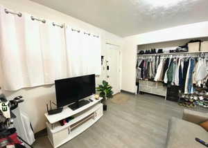 Living area with wood finished floors and baseboards