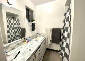 Full bath with vanity and a shower with shower curtain