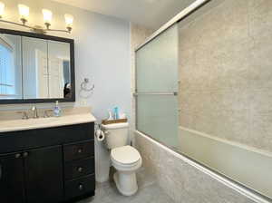 Bathroom featuring vanity and enclosed tub / shower combo