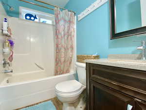 Bathroom with vanity, shower / tub combo, and wood finished floors