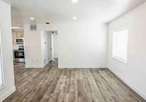 Unfurnished living room featuring dark wood finished floors and recessed lighting