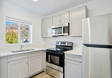 Kitchen featuring stainless steel appliances, light countertops, and light wood finished floors