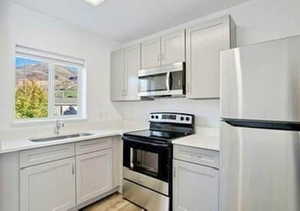 Kitchen featuring stainless steel appliances, light countertops, and light wood finished floors