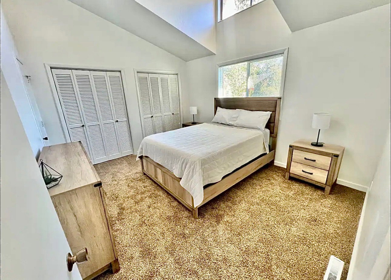 Bedroom featuring multiple closets and vaulted ceiling
