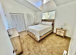 Bedroom featuring multiple closets and vaulted ceiling