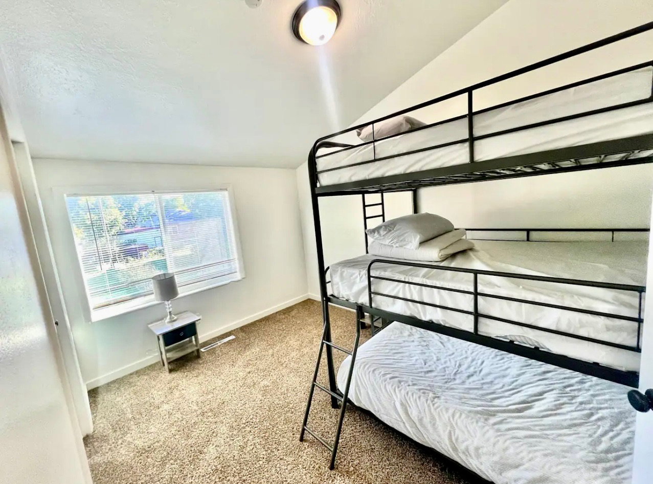 Bedroom with light carpet and vaulted ceiling