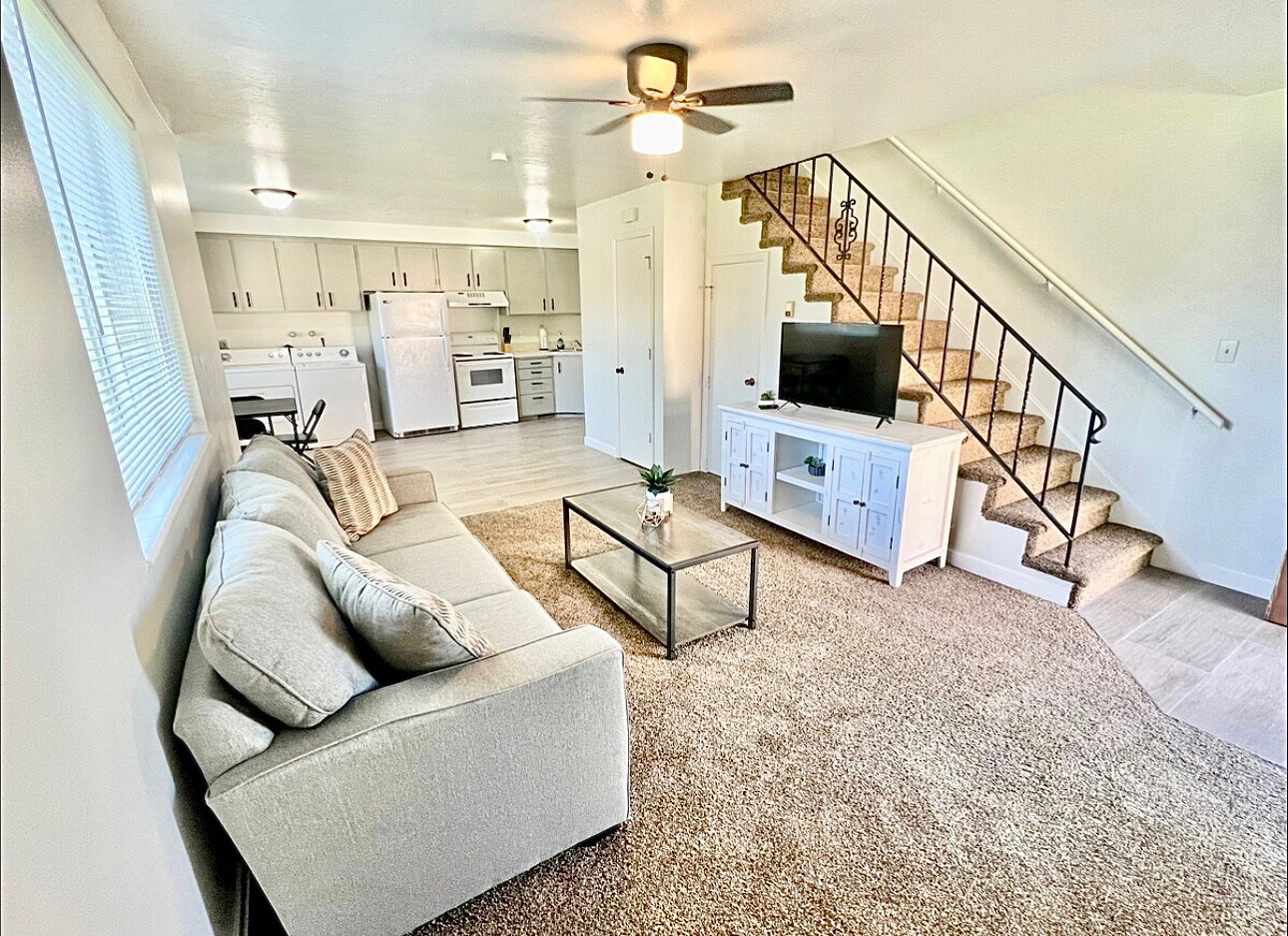 Living area featuring light wood-style flooring, washing machine and dryer, and ceiling fan