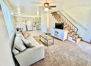 Living area featuring light wood-style flooring, washing machine and dryer, and ceiling fan
