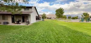 View of grassy yard featuring a patio