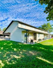 Rear view of house with a patio and a yard