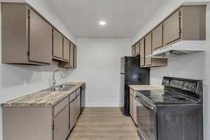 Kitchen featuring black appliances, light wood-style floors, and gray cabinetry