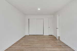 Unfurnished bedroom featuring light wood-style flooring and a closet