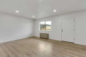 Family room with light wood-style floors and recessed lighting