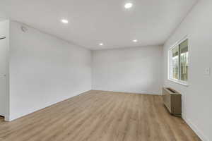 Family room with light wood-style floors and recessed lighting