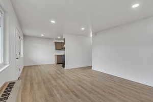 Family room with light wood-style floors and recessed lighting