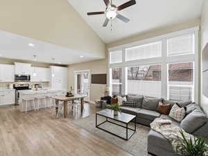 Living area featuring vaulted ceiling, ceiling fan, light wood-style flooring, french door