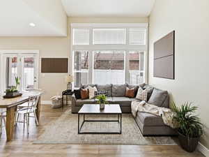 Great room featuring light wood-style flooring, high ceiling, majestic windows