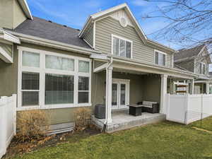 Rear view of house featuring a fenced backyard, french doors, an outdoor lounge area, and roof with shingles