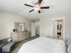 Bedroom with neutral colored carpet, lofted ceiling, and ceiling fan
