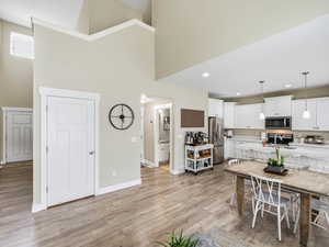 Dining space featuring light wood finished floors and an open high ceiling