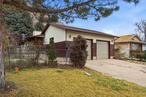 View of front of home with a garage and roof with shingles