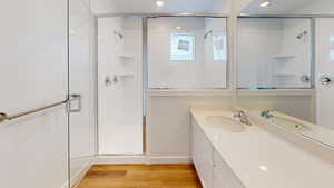 Full bath featuring vanity, light wood finished floors, a shower stall, and recessed lighting