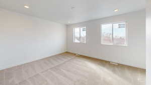 Spare room featuring light carpet and recessed lighting
