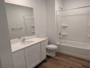 Bathroom with vanity, dark wood-type flooring, and tub / shower combination