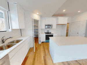 Kitchen featuring electric stove, white cabinets, light wood-style floors, a kitchen island, and stainless steel microwave
