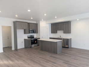 Kitchen featuring dark wood finish cabinets, stainless steel appliances, recessed lighting, a textured ceiling, and dark wood finished floors