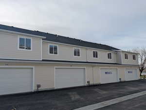 Back of house featuring a residential view and a shingled roof