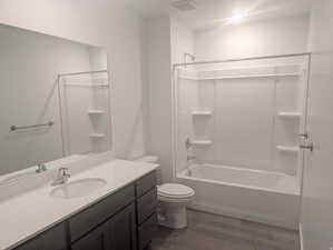 Bathroom featuring vanity, dark wood-style flooring, and shower / bathtub combination