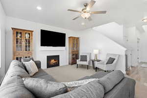 Living area featuring a fireplace, ceiling fan, and recessed lighting