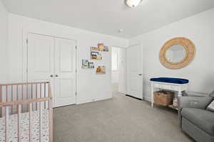 Bedroom featuring light colored carpet and a closet