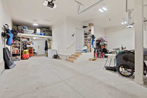Garage with a garage door opener and white fridge