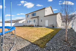 Back of property with a patio, a fenced backyard, stucco siding, and a trampoline