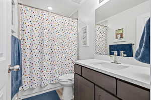 Bathroom featuring vanity and shower / bath combination with curtain