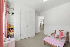 Living area featuring light carpet and baseboards