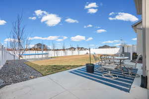 Fenced backyard with a patio area, outdoor dining area, a residential view, and a trampoline