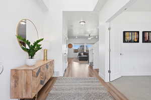 Hallway featuring light wood-type flooring and baseboards