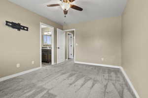 Unfurnished bedroom with light carpet, ceiling fan, and ensuite bath