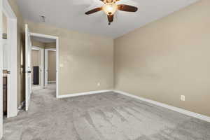 Empty room featuring light colored carpet and a ceiling fan