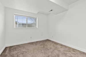 Unfurnished room with carpet and baseboards