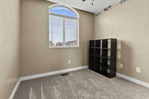 Empty room with light carpet and a ceiling fan