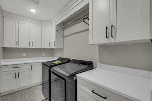 Laundry area with washing machine and dryer, cabinet space, and recessed lighting