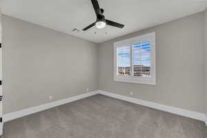 Empty room featuring light colored carpet and ceiling fan