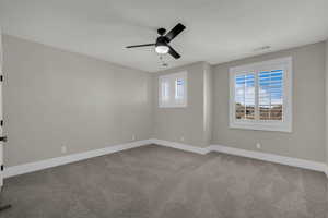 Spare room featuring carpet and ceiling fan