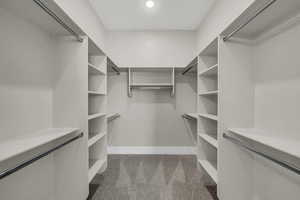 Walk in closet featuring light colored carpet