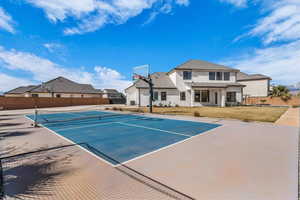View of tennis court featuring community basketball court, a patio area, and a residential view